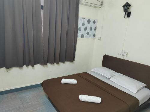 1 dormitorio con 1 cama con 2 toallas en Hotel Kenangan, en Kota Bharu