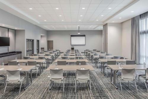 a conference room with tables and chairs and a screen at Embassy Suites by Hilton Atlanta Midtown in Atlanta