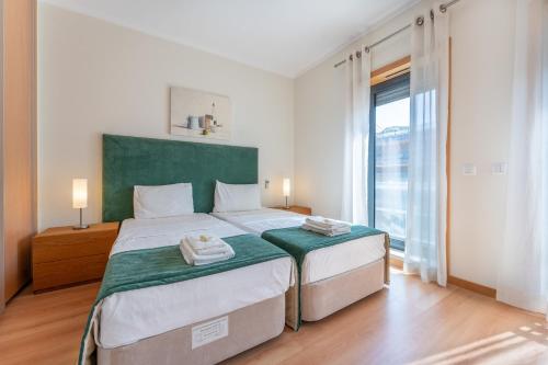 een slaapkamer met 2 bedden en een groot raam bij Apartamento Stella Maris in Olhão