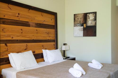 a bedroom with two beds and a wooden headboard at Olympian Bay Grand Resort in Leptokarya