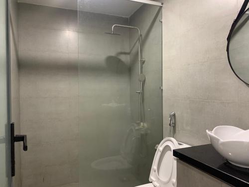 een badkamer met een douche, een toilet en een wastafel bij Coral Homestay Phan Rang -4BR in Phan Rang