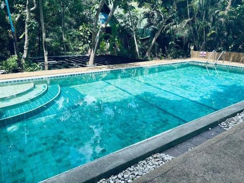 a large swimming pool with turquoise blue water at Chaweang cozy house 1 km.Lotus in Ban Ko Khwan