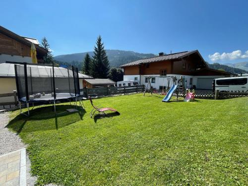 a yard with a playground with a slide in the grass at Alpenglück - Hinterthal in Hinterthal