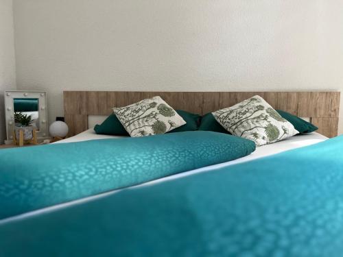 a bed with blue sheets and pillows on it at Guest House Eden in Bihać