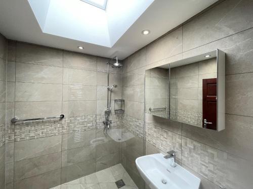 y baño con lavabo y espejo. en Addlestone Tranquil Spacious Three Bedroom Bungalow en Addlestone