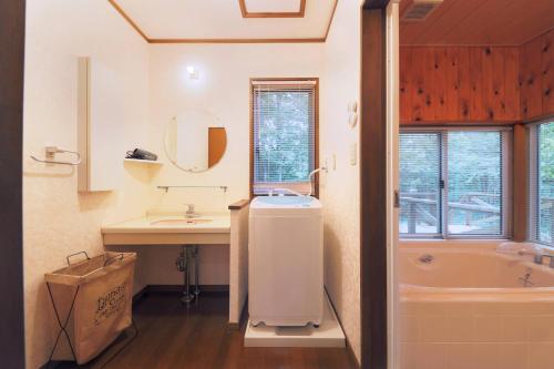 a bathroom with a sink and a tub and a mirror at CLIMB NASU in Nasu