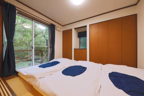 a bedroom with a bed and a large window at CLIMB NASU in Nasu