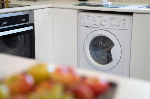 a washing machine in a kitchen with a pile of fruit at El Oasis Villa Resort in La Eliana