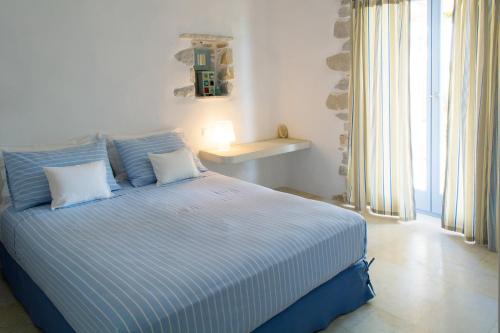 een slaapkamer met een bed met blauwe en witte strepen bij Kalma villa in Santa Maria