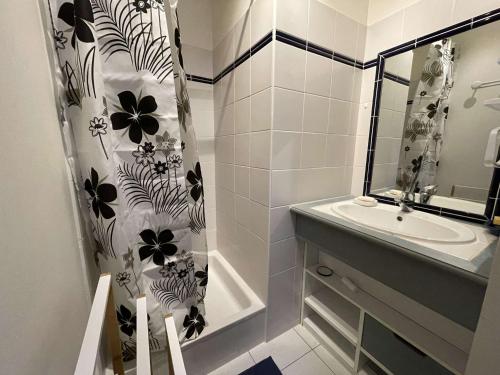 une salle de bain avec un lavabo et un rideau de douche dans l'établissement Charmante Maison 3 Pièces avec Piscines Chauffées, Terrasse et Jardin, à 300m de la Plage des Demoiselles - FR-1-224C-266, à Saint-Jean-de-Monts