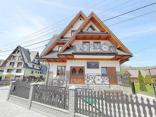 a house with a fence in front of it at Góralski Dworek in Biały Dunajec