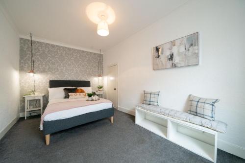 a bedroom with a bed and a bench in it at Coorie by the Coast - Arbroath in Arbroath