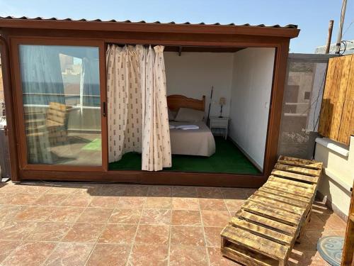 Habitación con cama en un patio con ventana en LA GEODA vivienda vacacional turística 8 personas en Villaricos