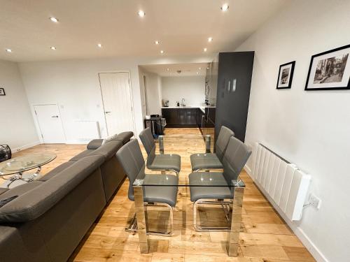 a waiting room with a long couch and chairs at Luxury 3 Bedroom Apt. Leeds Centre in Leeds