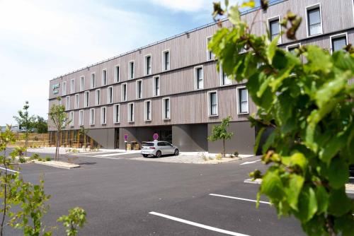 a car parked in a parking lot in front of a building at greet Hotel Rennes Pace in Pacé
