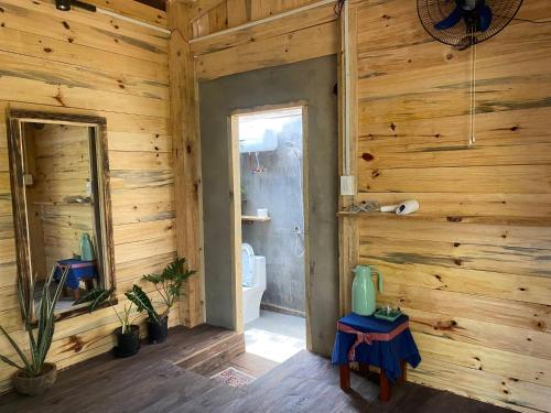 a bathroom with a toilet in a wooden wall at La Maison Homestay Măng Đen in Kon Tum