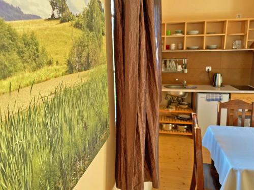 a kitchen with a painting of a field of grass at Siwejka - Ropki - Beskid Niski in Ropki