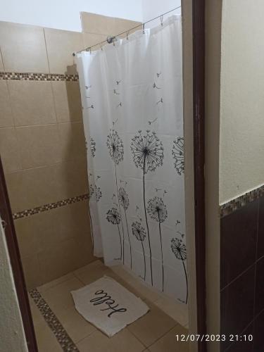 uma cortina de chuveiro com dentes-de-leão na casa de banho em Casa Las Moras em La Rioja