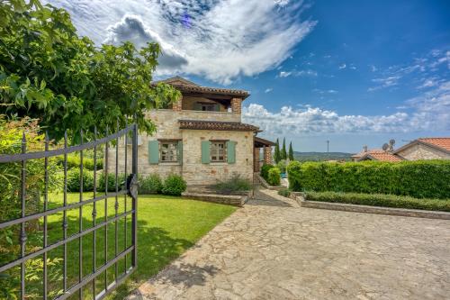 un portail en face d'une maison avec une clôture dans l'établissement Vila Amyra With Pool - Happy Rentals, à Sveti Lovreč Pazenatički