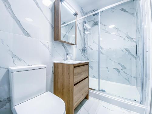 a bathroom with a shower and a toilet and a sink at Heathrow Airport Apartments by Elegance Living in Hounslow