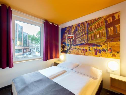 杜塞道夫的住宿－杜塞爾多夫市住宿加早餐旅館，卧室配有一张床,墙上挂有绘画作品
