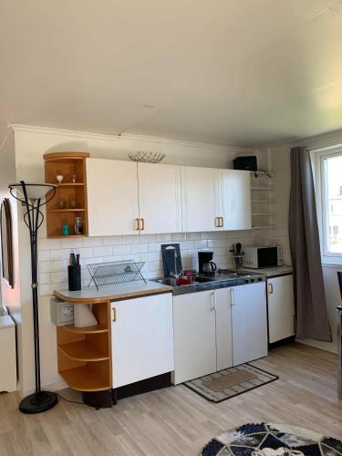 a kitchen with white cabinets and a counter top at Gäst lägenheten med egen terrass in Falkenberg