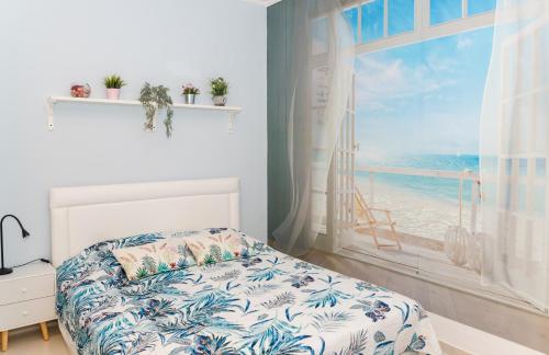 a bedroom with a bed and a window with a beach at Луксозен апартамент Далия in Varna City