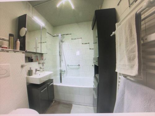 a bathroom with a bath tub and a sink at Ferienwohnung App 256 in Braunlage