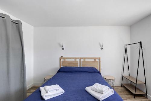 a bedroom with a blue bed with two towels on it at Maison Aveiro in Gafanha da Nazaré