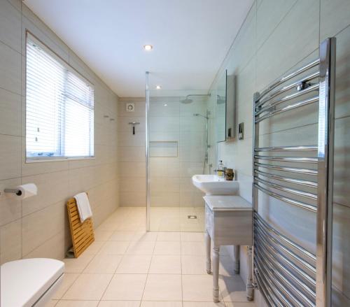 a bathroom with two sinks and a glass shower at Peaceful, country setting in Suffolk, near coast in Halesworth