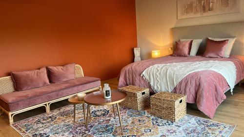 1 dormitorio con cama, sofá y mesa en Sol'm Lodges, en Solesmes