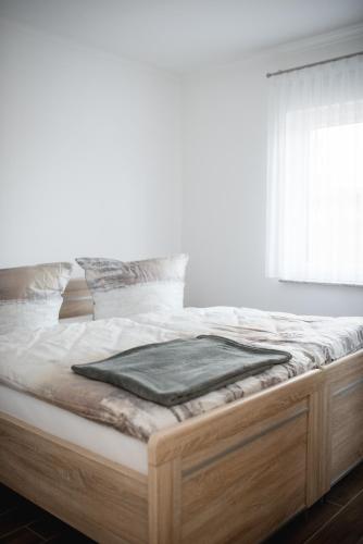 a white bedroom with a large bed with a window at Havelstern Ketzin, Ferienhaus Hecht in Ketzin