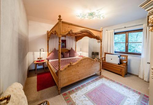 a bedroom with a canopy bed and a window at Romantische 5-Sterne- Ferienwohnungen in Mittenwald