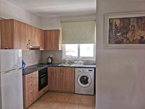 a kitchen with a white refrigerator and a dishwasher at Flemigks 1 bedroom appartement in Larnaka
