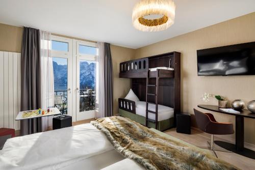 a bedroom with a bunk bed and a desk at Märchenhotel in Braunwald