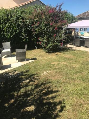 two benches sitting in a yard with a bush at House with large private garden in Villereal in Villeréal