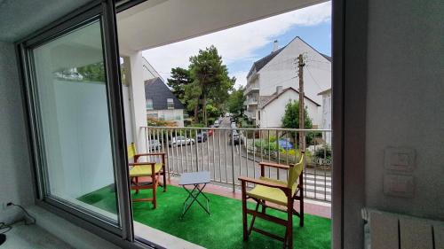 d'un balcon avec 3 chaises et une table sur gazon. dans l'établissement LA BAULOISE, à La Baule