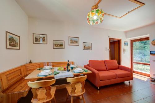- un salon avec une table et une chaise rouge dans l'établissement Charming Magognino Stresa Hills Lake View - Happy Rentals, à Stresa