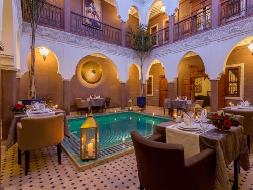 un restaurante con piscina en medio de un edificio en Riad Magda & Spa en Marrakech