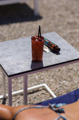 a drink sitting on a table with a pen on it at Belvedere Hotel & SPA in Vlorë