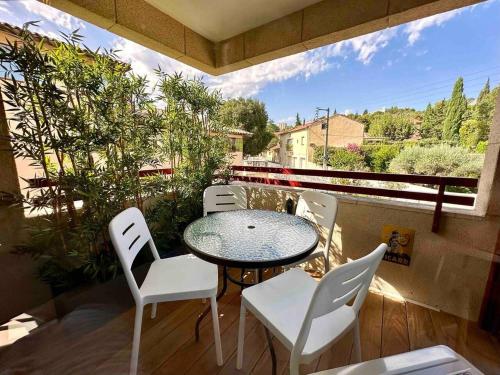 a patio with a table and white chairs on a balcony at Centre ville AIX - Terrasse / Ascenseur - Rénové in Aix-en-Provence