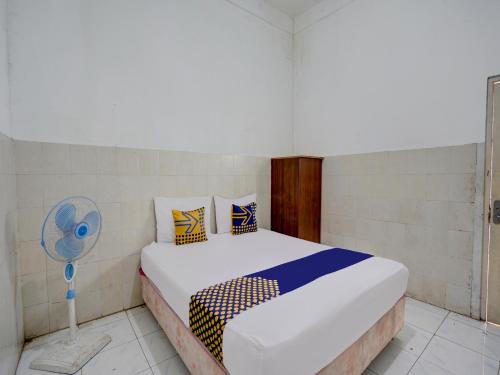 Schlafzimmer mit einem Bett und einem Ventilator in der Unterkunft SPOT ON 92876 Homestay Kedamean in Gresik