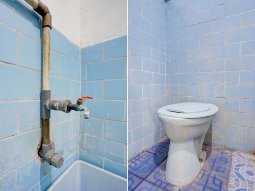ein blau gefliestes Bad mit einem WC und einer Badewanne in der Unterkunft SPOT ON 92876 Homestay Kedamean in Gresik