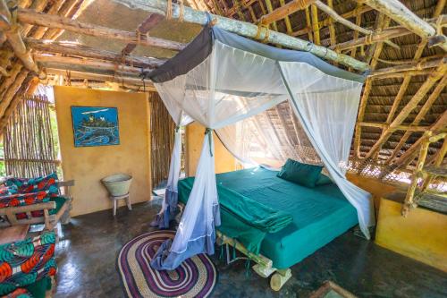 a bedroom with a bed with a mosquito net at Chumbe Island Coral Park in Mbweni