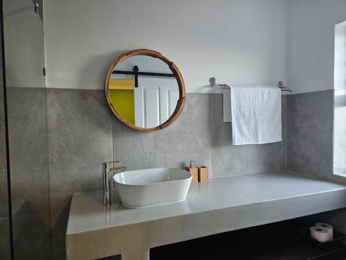 a bathroom with a white sink and a mirror at C-Rock Holiday Home Jacobs Bay in Jacobs Bay