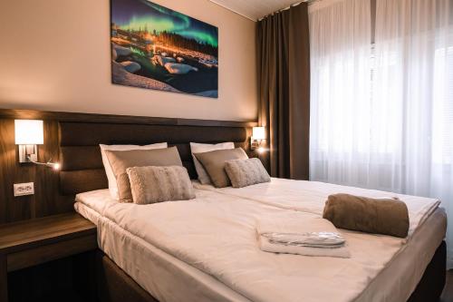 a hotel room with a large white bed in a room at Hotel Boreas in Rovaniemi