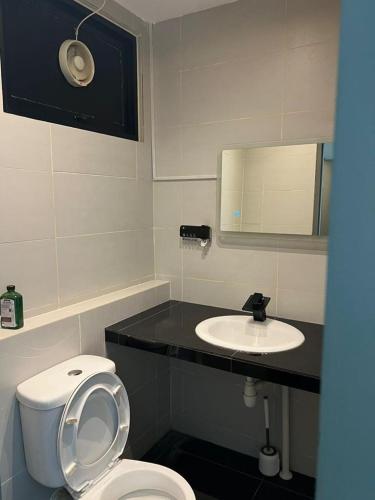 La salle de bains est pourvue de toilettes blanches et d'un lavabo. dans l'établissement HK Square Studio, à Kuching