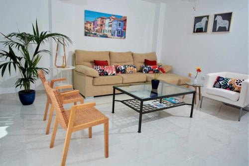 ein Wohnzimmer mit einem Sofa, einem Tisch und Stühlen in der Unterkunft Bonita vivienda con vistas al mar playaWIFI in Radazul