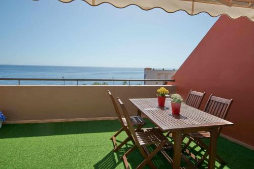 a table and chairs on a balcony with the ocean at Bonita vivienda con vistas al mar playaWIFI in Radazul