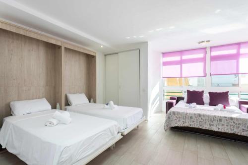 1 Schlafzimmer mit 2 Betten und einem großen Fenster in der Unterkunft Estudio Océano Indico con piscina y mar y vistas in Santa Cruz de Tenerife